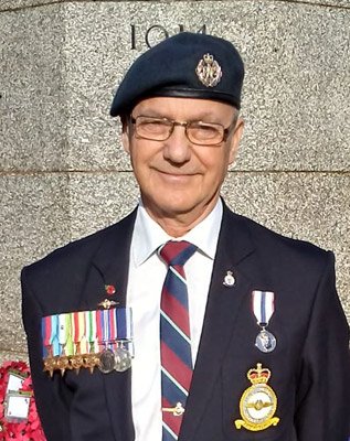 Ken Johnsonn at the War Memorial in Bury wearing his father's medals.